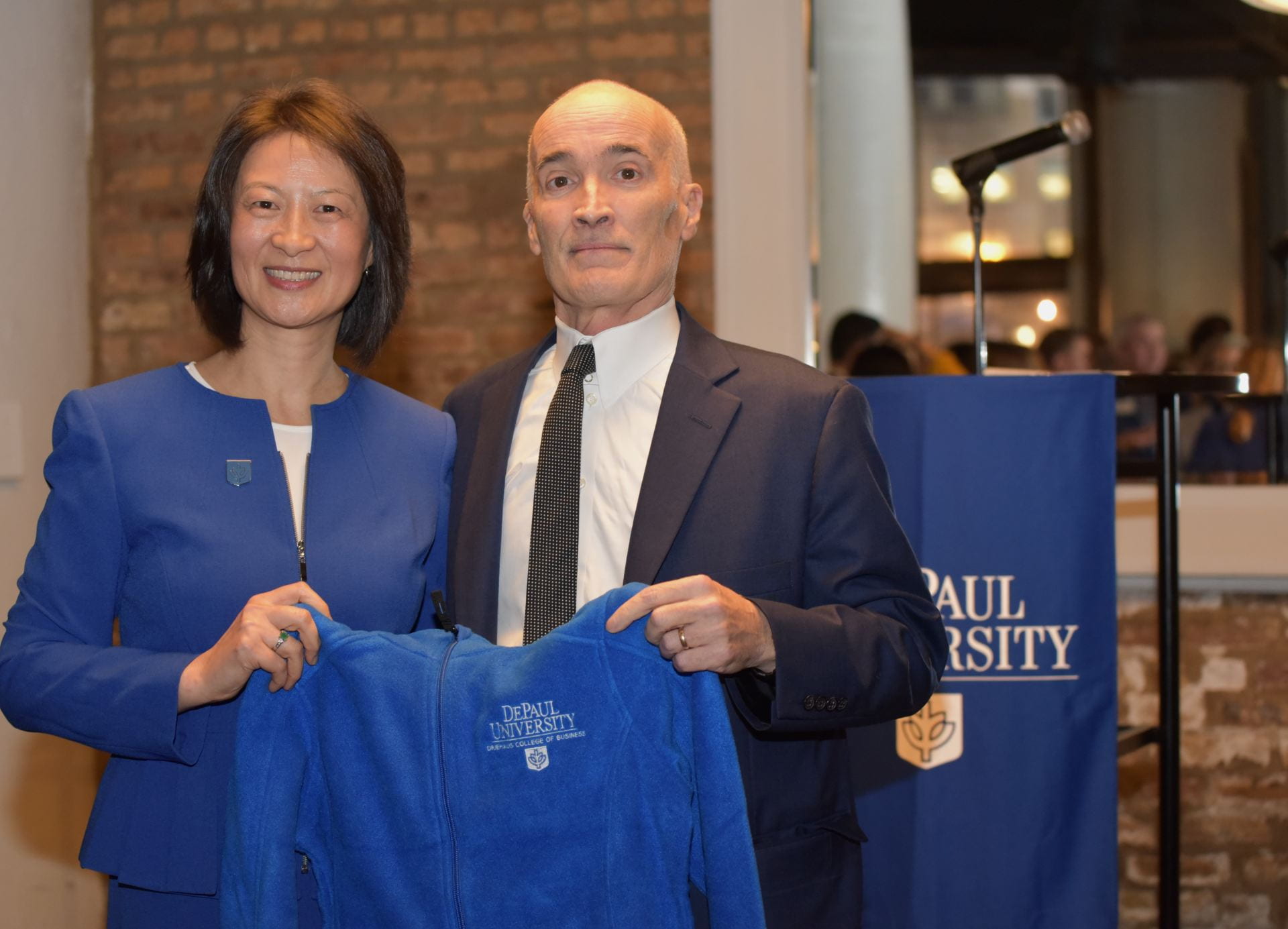 Interim Business Dean Thomas Donley welcomed Sulin Ba to DePaul by presenting her with a Driehaus College of Business jacket. (Photo By Kathy Hillegonds)