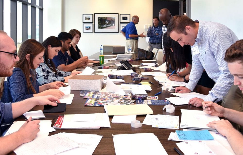 Anissa Patterson (seated fifth on the left) and DePaul sports business classmates review fan letters as part of a customer service consulting project for the Chicago Cubs baseball organization. (Photo by Kathy Hillegonds)