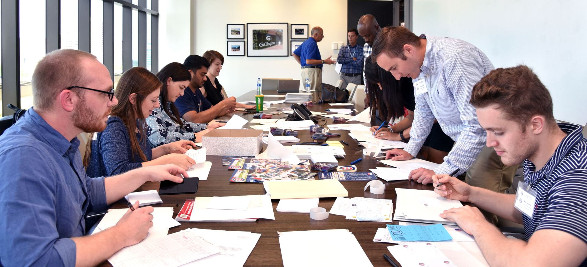 Anissa Patterson (seated fifth on the left) and DePaul sports business classmates review fan letters as part of a customer service consulting project for the Chicago Cubs baseball organization. (Photo by Kathy Hillegonds)