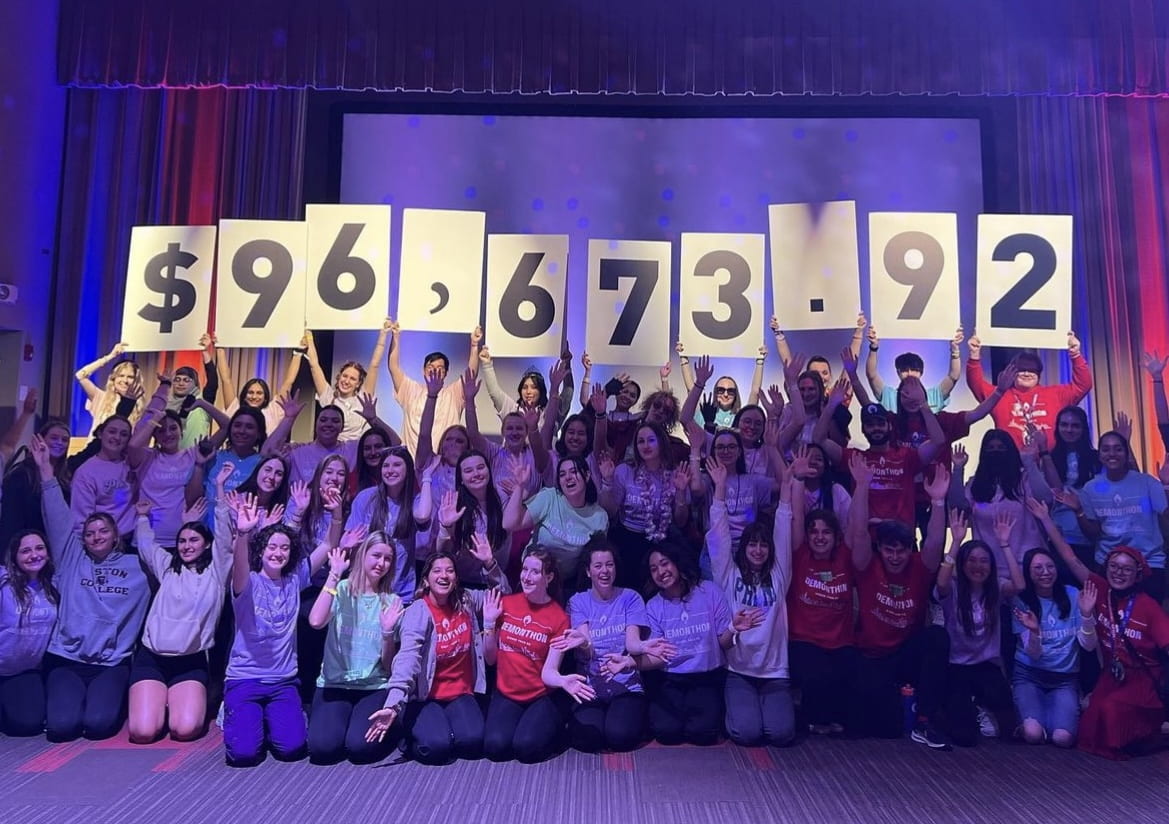 The participants of the DemonTHON Dance Marathon pose for a photo and Jeff is hidden in the back holding up part of a group sign displaying the $96,673.92 total that DemonTHON raised.