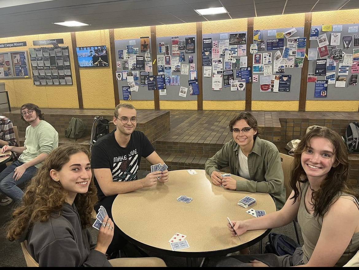 Jeff and three other members of the DePaul University Euchre Club sit at a table playing euchre.