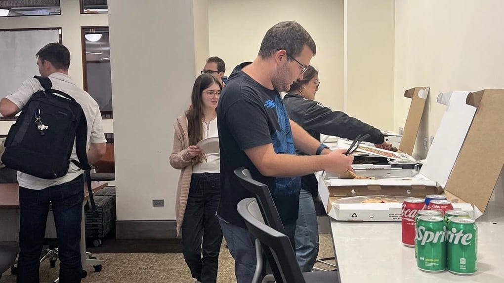 Sienna and other students at a DePaul CEO meeting grabbing pizza before the start of the meeting.