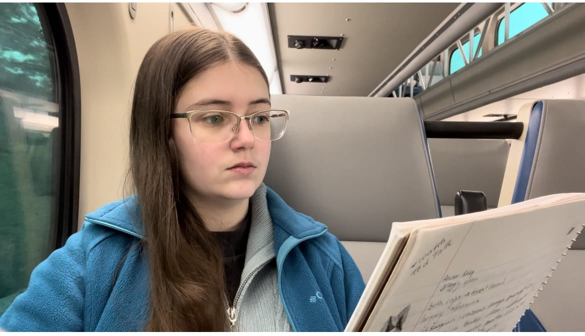 Sienna with a notebook studying for finals, on the metra train.