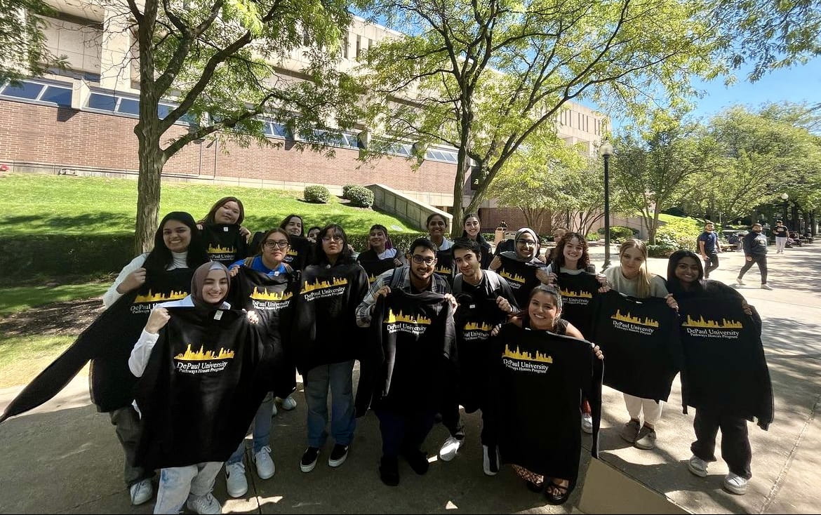 A large group of Pathways Honors students smiling for a group photo. Each wears a branded Pathways Honors sweatshirt, in black and yellow.