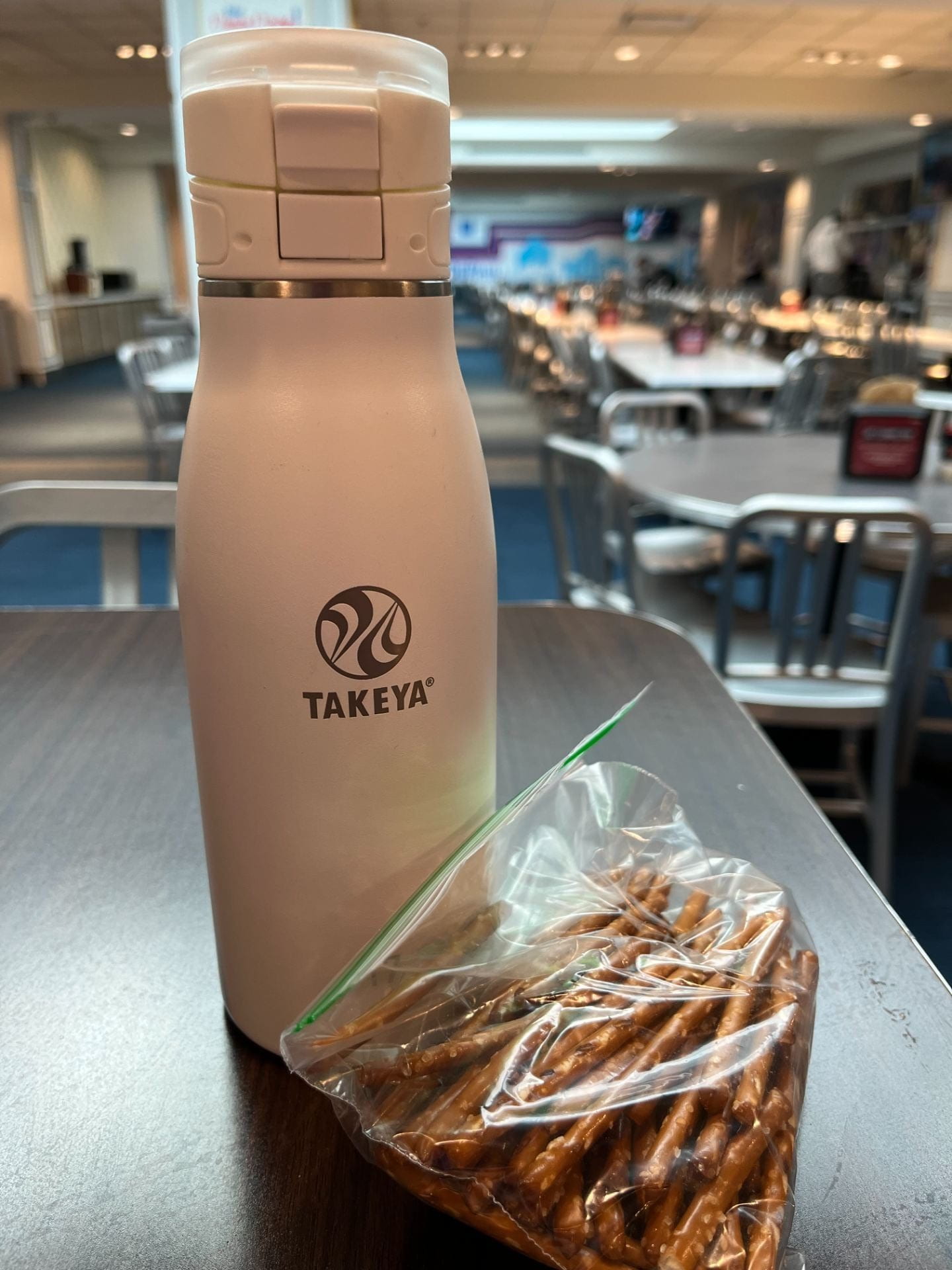 A white thermos with a bag of pretzels sitting next to it inside DePaul’s cafeteria