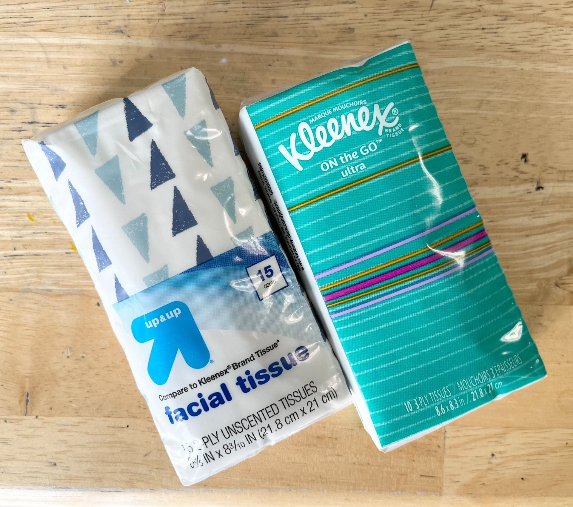 Two colorful travel size tissue packets. 