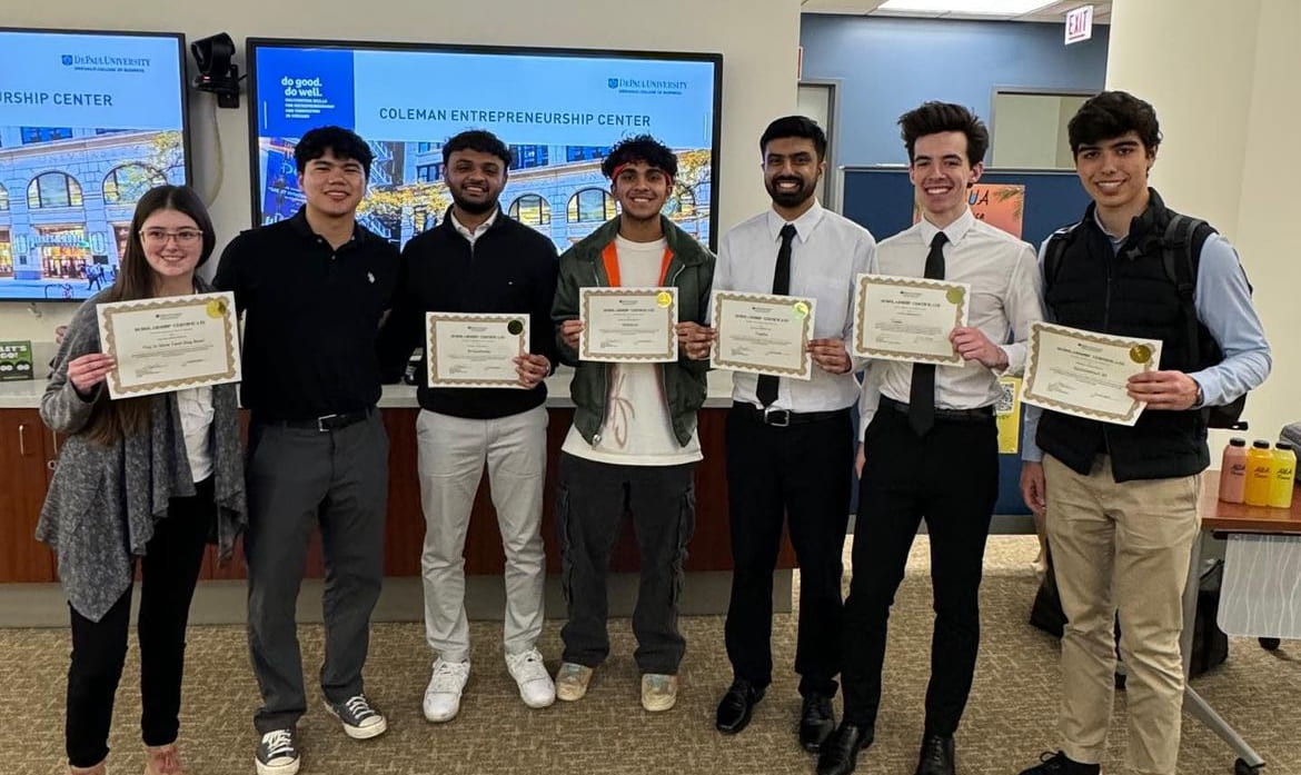 A group of college students all holding up their certificates for being apart of the Student Innovation Expo and smiling.
