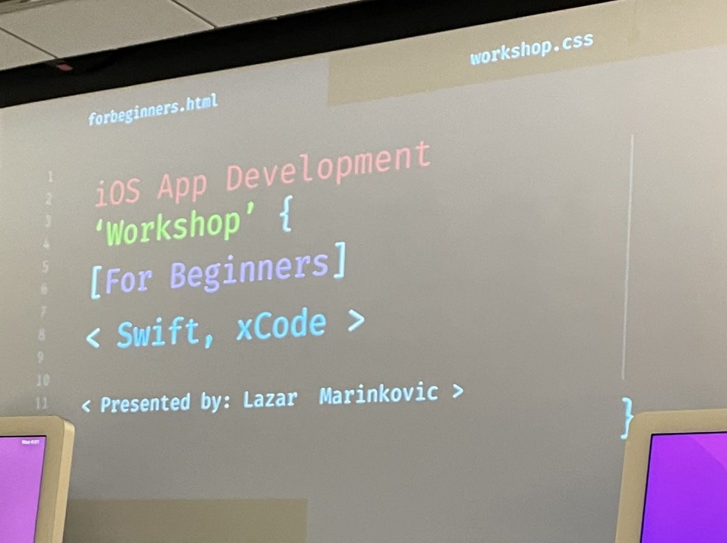 A projector screen shows some code titling an IOS development workshop put on by the DePaul University Computer Science Society.