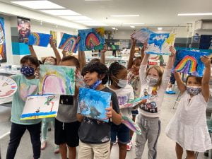A group of kids display their art as part of the Give Kids Art program.