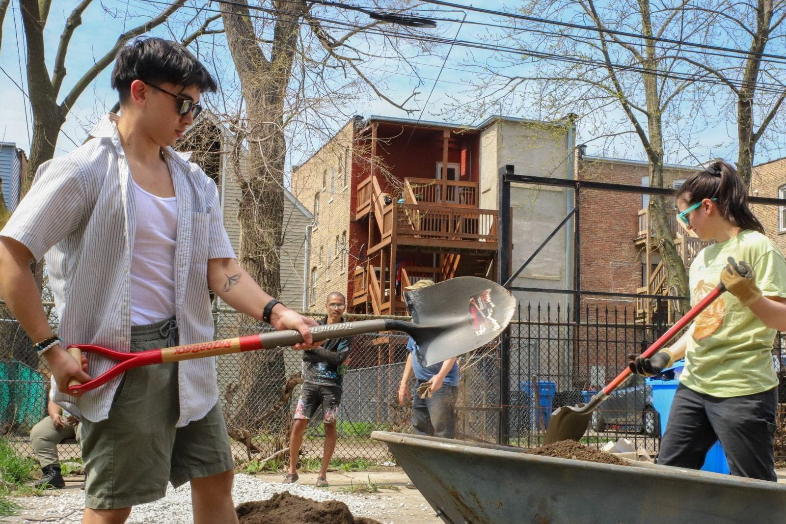 Two DePaul students wearing sunglasses work with shovels in a community garden in early spring. 

Photo by Quentin Blais, DePaul Journalism.